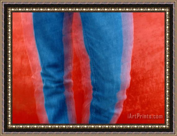 Raymond Gehman Vibrant Blue Jeans Against a Red Background Framed Painting