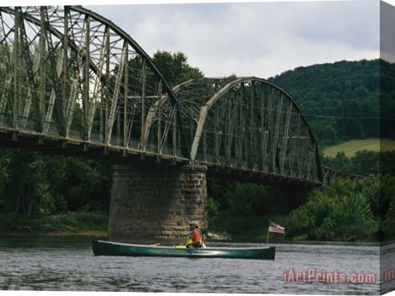 Raymond Gehman A Canoeist Passes Under a Bridge on The Susquehanna River Stretched Canvas Print / Canvas Art