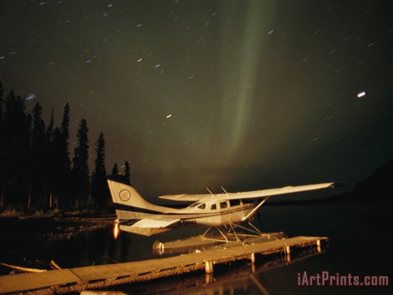 The Aurora Borealis Glows Brightly Over a Seaplane Docked on Cli Lake painting - Raymond Gehman The Aurora Borealis Glows Brightly Over a Seaplane Docked on Cli Lake Art Print