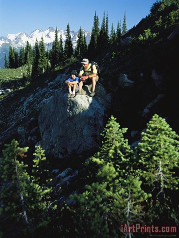 Raymond Gehman Two Hikers Rest on a Rock Amid Evergreen Trees Art Painting