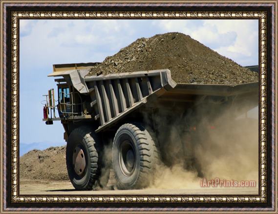 Raymond Gehman A Dump Truck Carrying Gravel Kicks Up a Cloud of Dust Framed Print