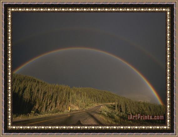 Raymond Gehman A Rainbow Arches Over The Alaska Highway in British Columbia Canada Framed Print