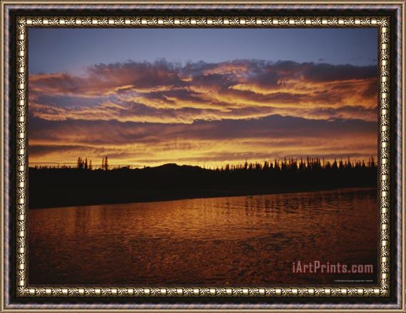 Raymond Gehman An Intense Sunset Colors Clouds And The Water of The Mackenzie River Framed Print