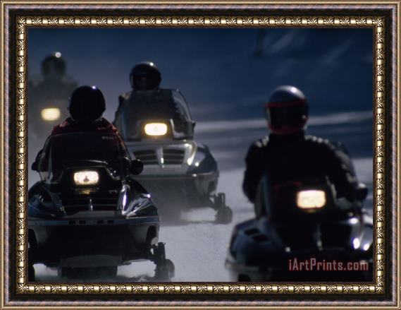 Raymond Gehman Snowmobilers Ride Down a Snowy Road in Yellowstone Park Framed Painting