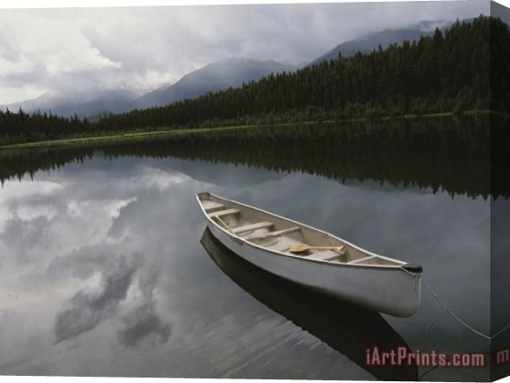 Raymond Gehman A Canoe Sits Tethered to Shore on a Beautiful Mountain Lake Stretched Canvas Print / Canvas Art
