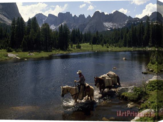 Raymond Gehman A Guide Leads a Pack String Across The North Popo Agie River Below Cirque of The Towers Peaks Stretched Canvas Painting / Canvas Art