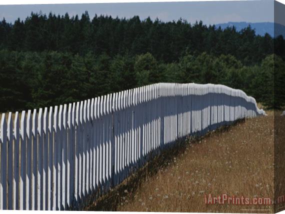 Raymond Gehman A White Picket Fence Recedes Down a Field Stretched Canvas Print / Canvas Art