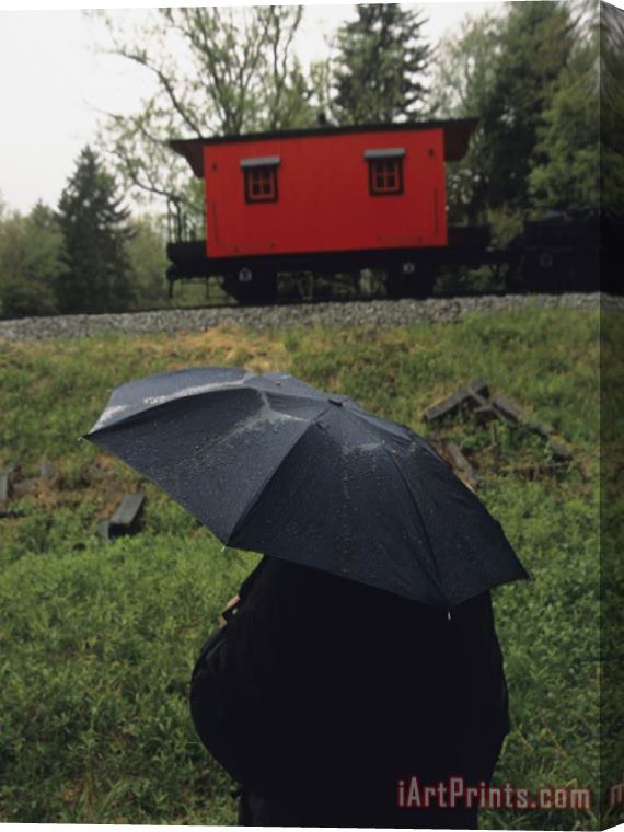 Raymond Gehman Person Under an Umbrella Looking at a Parked Train Caboose Stretched Canvas Painting / Canvas Art