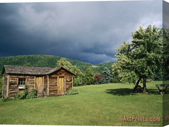 Raymond Gehman Storm Clouds Form Above a Log Cabin on The Site of French Azilum Stretched Canvas Print / Canvas Art